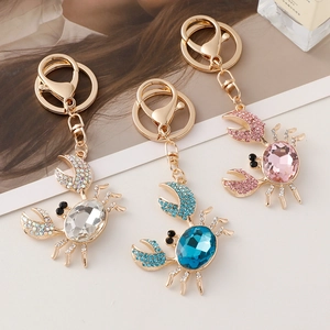 Trois porte-clés crabe en cristal avec pierres précieuses étincelantes et métal doré