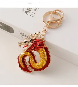 Detailed macro view of a golden dragon keychain with red enamel on white book background