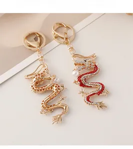 Détails de deux porte-clés dragon avec cristaux et perles sur alliage plaqué or