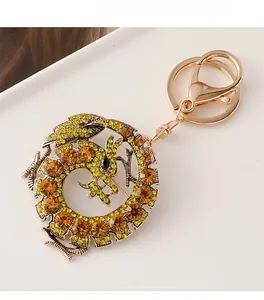 Gros plan du porte-clés dragon du zodiaque doré orné de strass jaunes et ambrés
