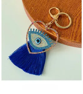 Détail du porte-clés œil maléfique en forme de cœur avec strass bleus et pompon en soie