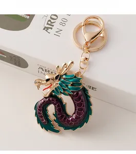 Close-up of golden Chinese dragon keychain with green and purple enamel scales