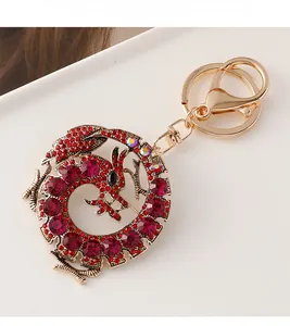 Détail d'un porte-clés dragon doré avec des strass rouges et un fermoir à ressort