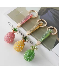 Close-up of sparkling rhinestone pineapple keychains in pink, yellow, and green colors