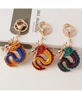Close-up of colorful enamel Chinese dragon keychains in blue, red, and purple on a white book