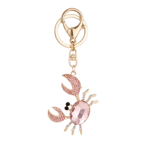 Porte-clés crabe doré orné de cristal rose et de strass sur fond blanc épuré