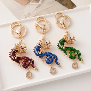Three Chinese dragon keychains with rhinestones in red, blue, and green alloy colors