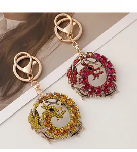 Détail de porte-clés dragon avec strass et alliage doré sur un fond blanc neutre