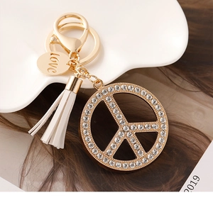 Detail of peace sign keychain with white rhinestones, PU tassel, and love engraved tag