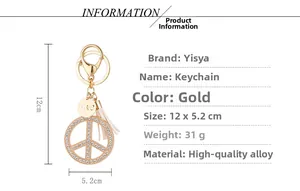 Detailed view of gold peace sign keychain with crystals, white tassel and LOVE charm