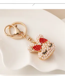 Close-up of pearl Minnie mouse keychain with red rhinestone bow on white ceramic plate