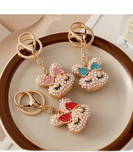 Close-up of pearl-encrusted rabbit keychains with colorful rhinestone bows and gold plating