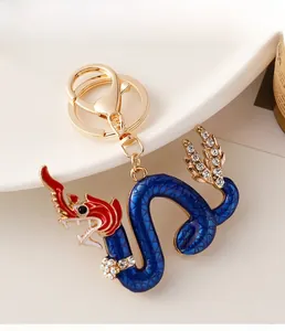 Detailed macro of golden Chinese dragon keychain with blue enamel and sparkling rhinestones