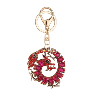 Porte-clés et broche dragon avec cristaux rouges sur une monture dorée élégante