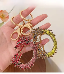 Porte-clés dragon avec strass en cristal et fermoir doré présentés dans la main
