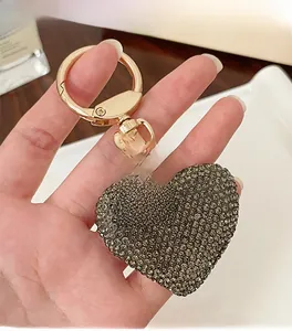 Detailed view of rhinestone heart keychain with gold plating and engraved metal tag