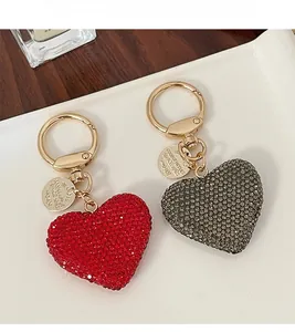 Detail of red and grey rhinestone heart keychains with golden metal carabiners