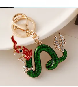 Close-up of green and red enamel dragon keychain with sparkling rhinestones and gold plating