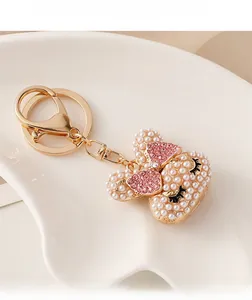Macro shot of pearl-encrusted rabbit charm with pink rhinestone bow on ceramic tray