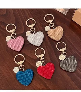 Detail of colorful rhinestone heart keychains in various colors on dark wood background