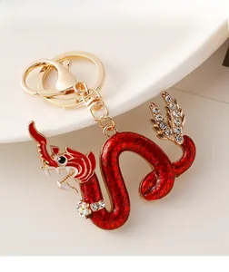 Detail of red dragon keychain with gold texture, sparkling rhinestones and metal clasp