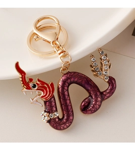 Detail of red enamel dragon keychain with sparkling rhinestones and golden lobster clasp