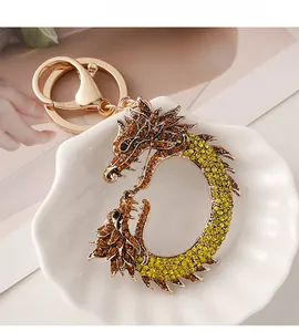 Vue détaillée du porte-clés dragon avec des strass jaunes et ambrés sur métal doré
