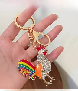 Detailed view of rhinestone-encrusted rooster keychain with colorful enamel tail