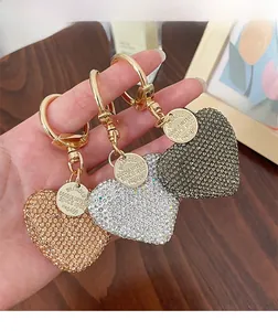 Close-up of heart-shaped rhinestone keychains in gold, silver, and grey colors