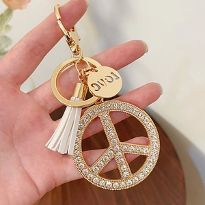 Golden peace sign keychain with sparkling rhinestones, white tassel and LOVE charm