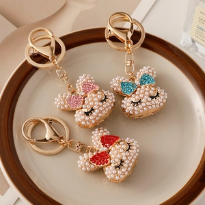 Adorable pearl rabbit head keychains with rhinestone bows in pink, blue, and red colors