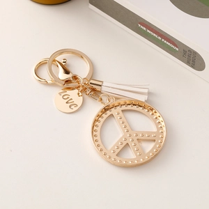 Golden peace sign keychain with white leather tassel and engraved love charm for bags