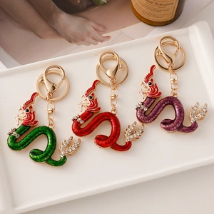 Golden dragon keychain with colorful enamel scales and crystals in three vibrant colors