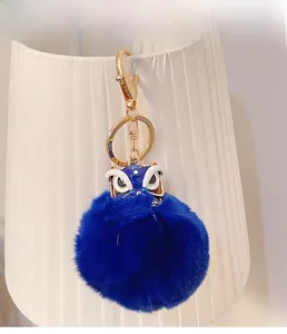 Vue détaillée du porte-clés danse du lion en peluche bleue avec anneau en métal doré