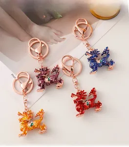 Detailed close-up of colorful enamel Kirin keychains with inlaid green gemstones and rose gold clips