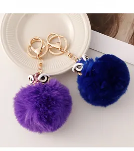 Détail des porte-clés danse du lion en peluche bleue et violette avec fourrure et fermoir doré