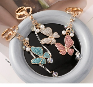 Detailed macro of crystal butterfly keychains with rhinestones and pearls on a display tray