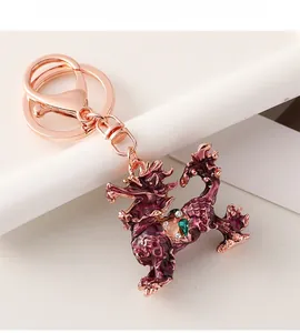 Macro shot of purple enamel mythical beast keychain with rose gold plating and gemstone details
