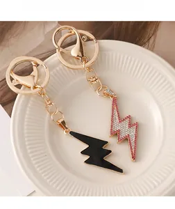 Detail of hip hop lightning bolt keychains with crystals and black enamel finish