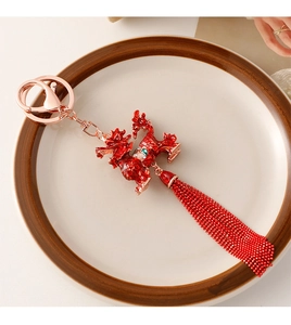 Detail of red Chinese dragon keychain with gold metal hooks and beaded tassel decor