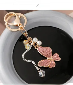 Detailed macro view of butterfly keychain with pink crystals and artificial pearls
