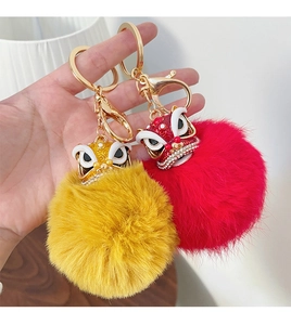 Détail de porte-clés danse du lion chinois rouge et jaune avec strass et boules en peluche