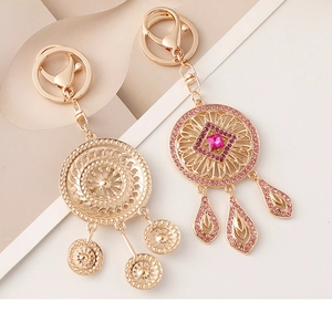 Detailed view of alloy dreamcatcher keychains featuring pink rhinestones and gold plating