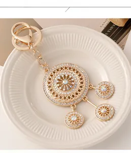 Macro view of gold dreamcatcher keychain with white rhinestones and iridescent stones