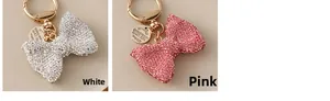 Detail showing white and pink rhinestone bow keychains with gold metal rings