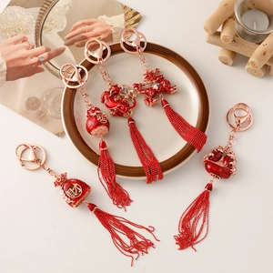 Traditional Chinese style keychain with red tassels and dragon charms in gold finish