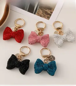 Detail view of sparkling bow-knot keychains in five colors with rhinestones and gold rings