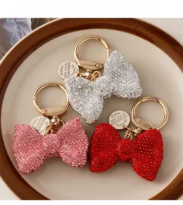 Macro shot of rhinestone bow keychains with gold spring rings and metal tags in three colors