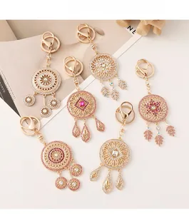 Detailed close-up of dreamcatcher keychains with rhinestones and elegant gold plating