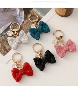 Close-up of five rhinestone bow keychains in various colors on a stylish background